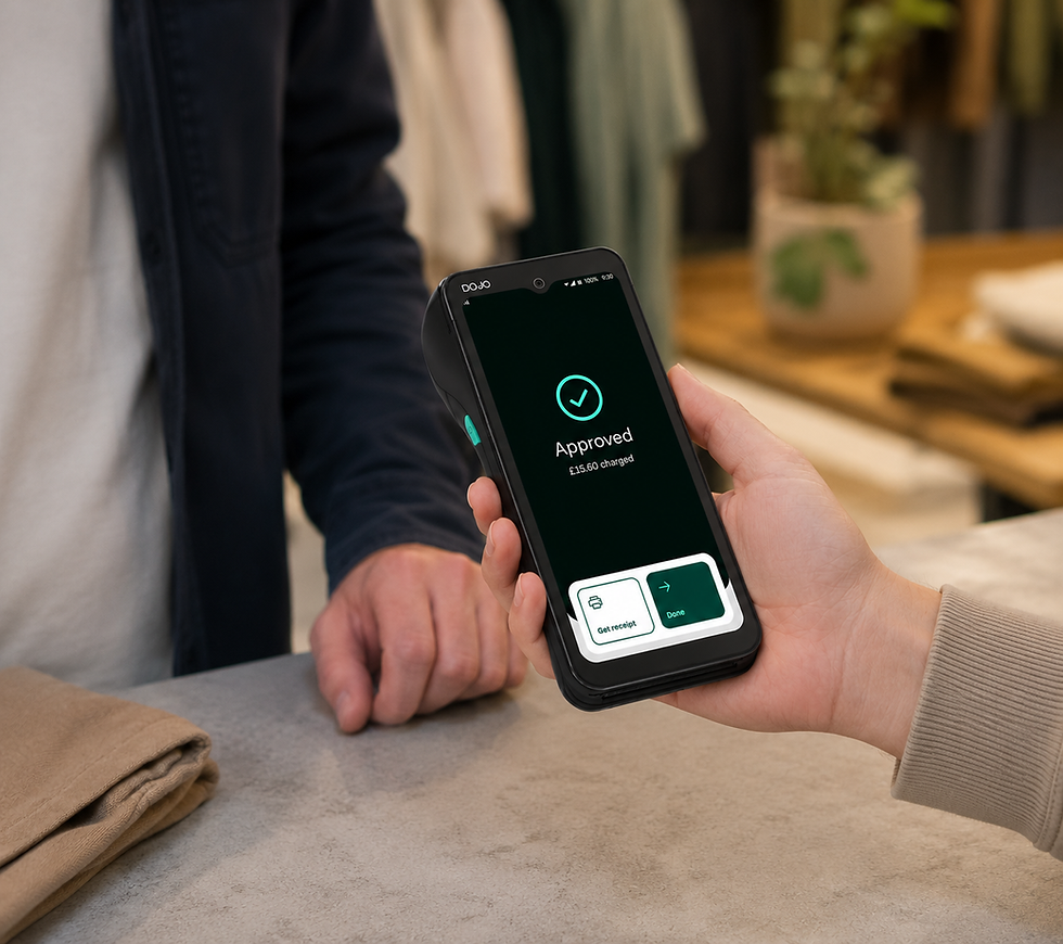 Hand holding the black Dojo Go Max card machine showing an approved payment notification in a UK retail shop