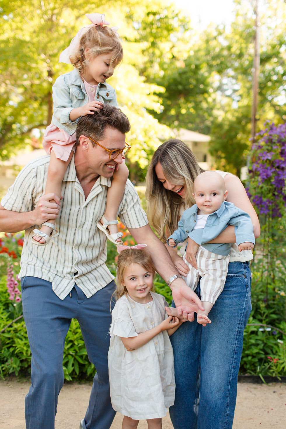 Smiling family of five outdoors in a garden, with parents holding three young children in soft pastel clothes.
Spring Family Photoshoot at Elizabeth Gamble Garden, Palo Alto by Bay Area Photographers HKCreate