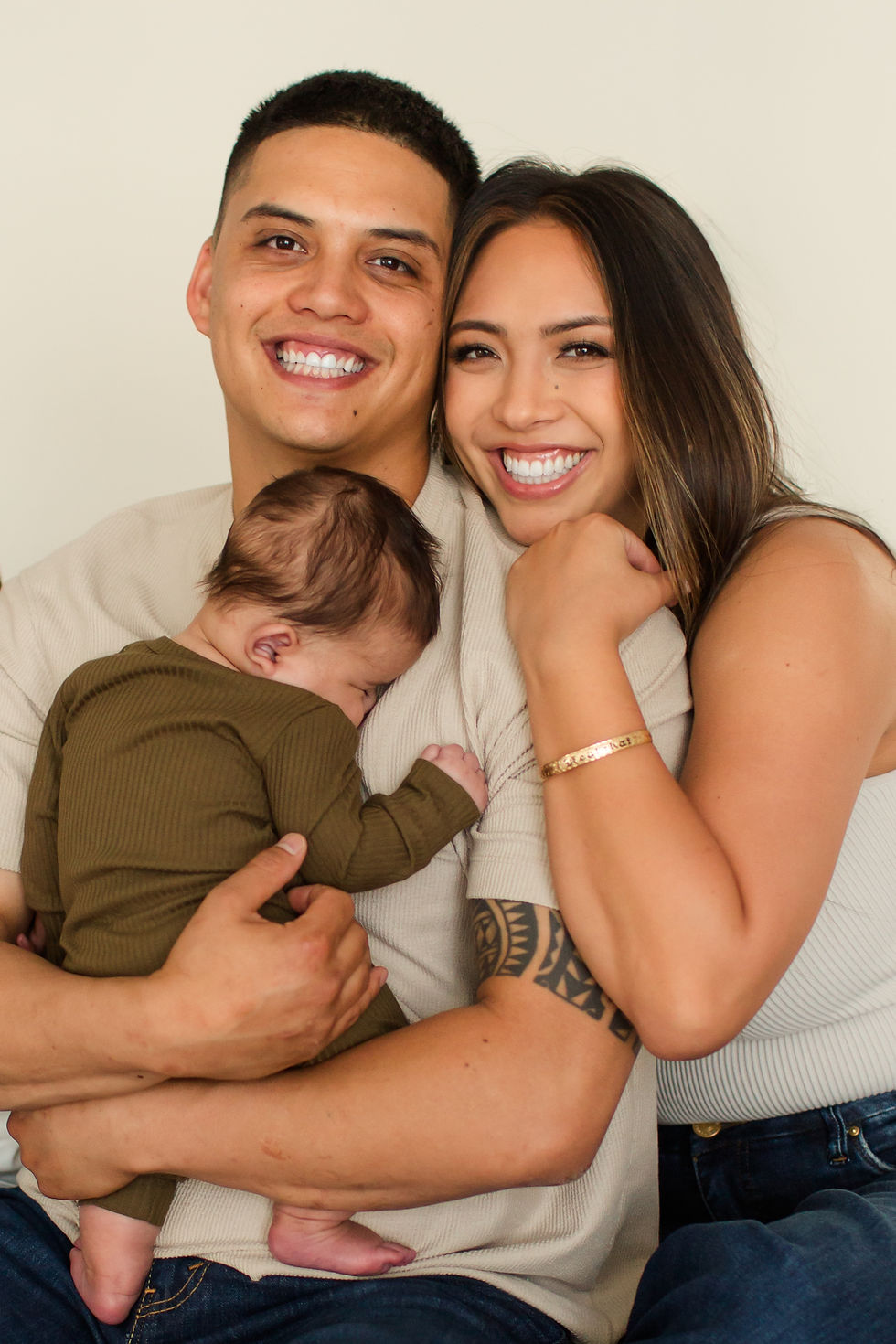Smiling couple embraces while holding a sleeping baby, dressed in olive green, against a neutral background, conveying warmth and happiness.
Lifestyle Studio Photoshoot in Cupertino by HKCreate Bay Area Photographers