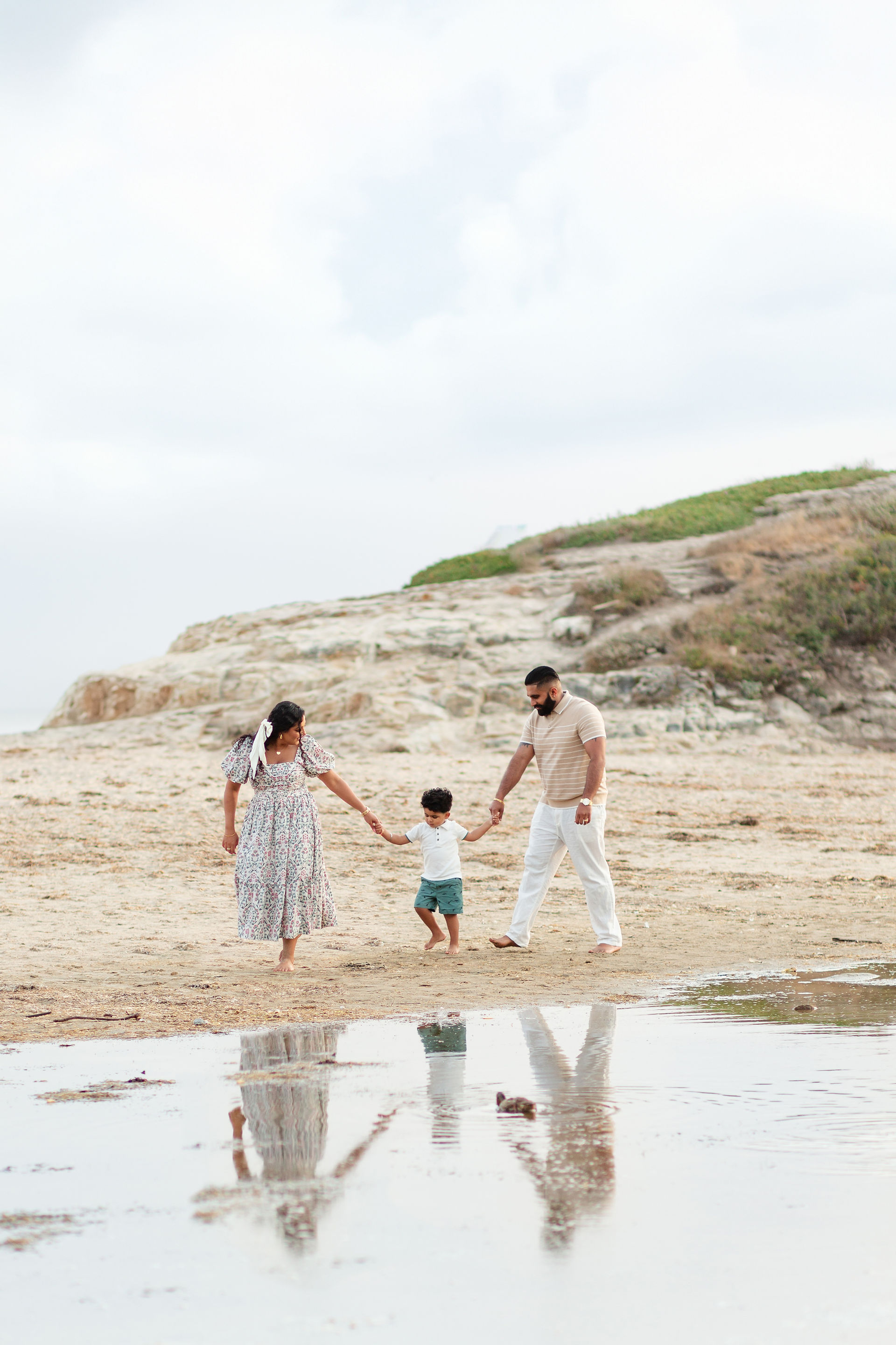 hkcreate bay area photography joyful candid light and airy san jose photographers northern california photoshoot natural bridges state beach santa cruz family photoshoot summer joyful happy fun light and airy photography family holding hands walking on the beach with reflection in the water