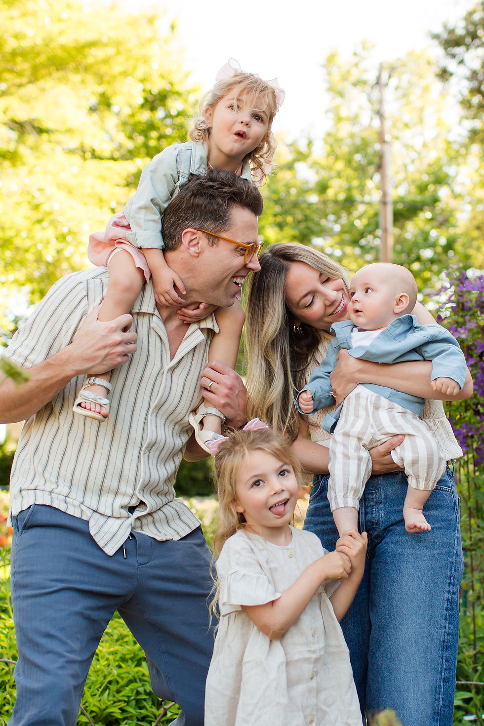 Smiling family of five in a sunny garden, with dad and mom holding three young children.
Spring Family Photoshoot at Elizabeth Gamble Garden, Palo Alto by Bay Area Photographers HKCreate