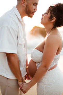 Couple holding hands at the beach with glow in the background. Joyful, serene and peaceful photos. Woman wearing a white lace dress. Maternity session at Cowell Ranch State Beach in Half Moon Bay by HKCreate Bay Area Photographers