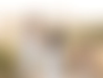 Family in a field, man carrying child on shoulders, woman holding hands with both, smiling. Tall grasses, soft light in background. Rockaway Beach, Pacifica Golden Hour Maternity Family Photoshoot by HKCreate Bay Area Photographers