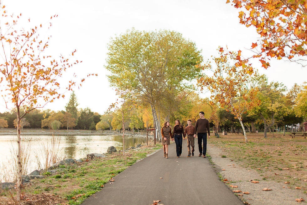 Family walking on a scenic path by a lake in autumn, surrounded by trees with yellow and orange leaves. Relaxed and joyful mood.
Hellyer County Park in San Jose fall family photoshoot with dog by Bay Area photographers HKCreate About the Location Guide