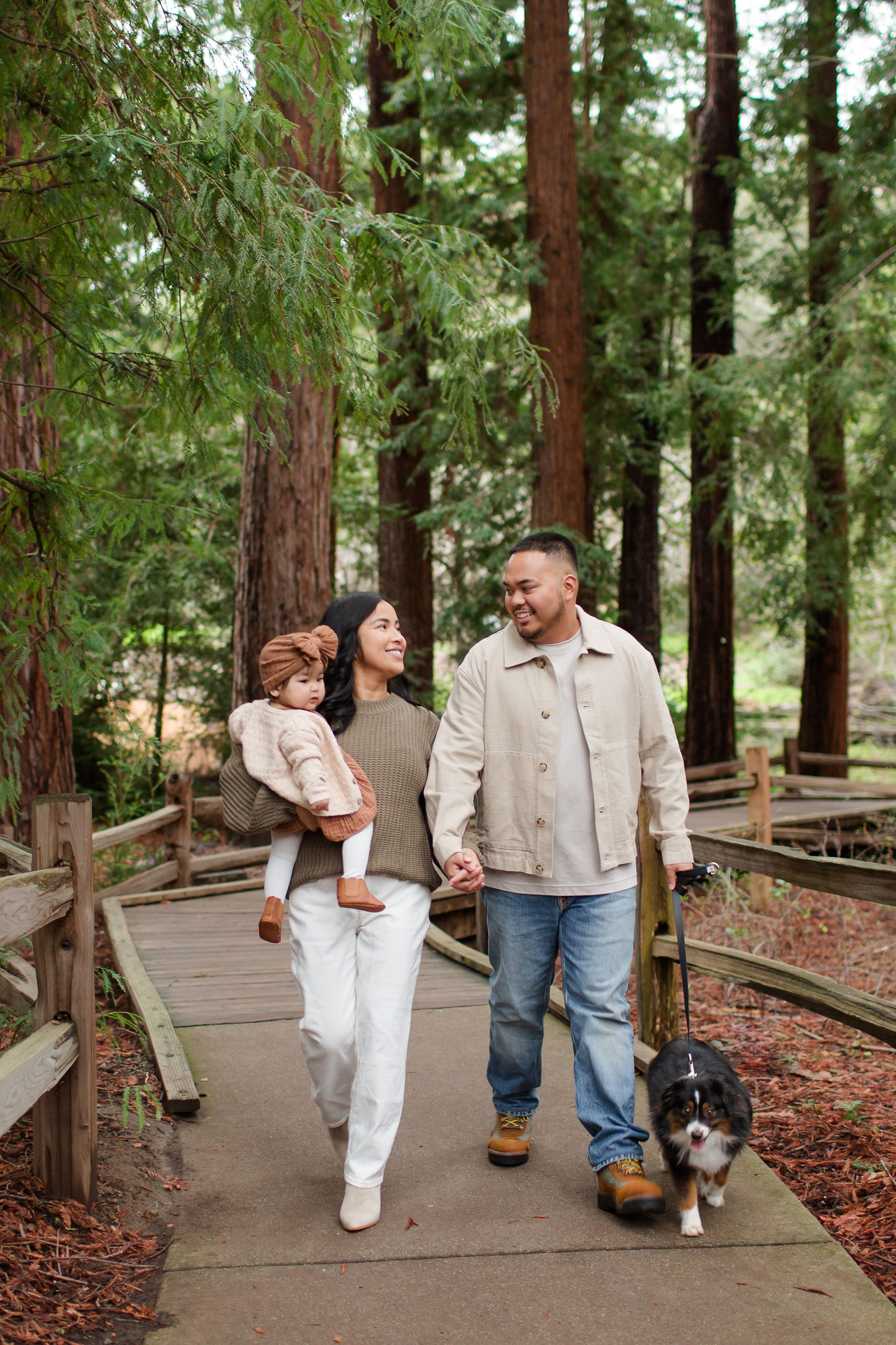 hkcreate bay area photography joyful light and airy san jose photographers northern california photoshoot legacy extended family neutral outfit ideas sweaters winter forest redwood grove nature preserve los altos family of three baby girl with dog walking cream and russet brown outfit ideas