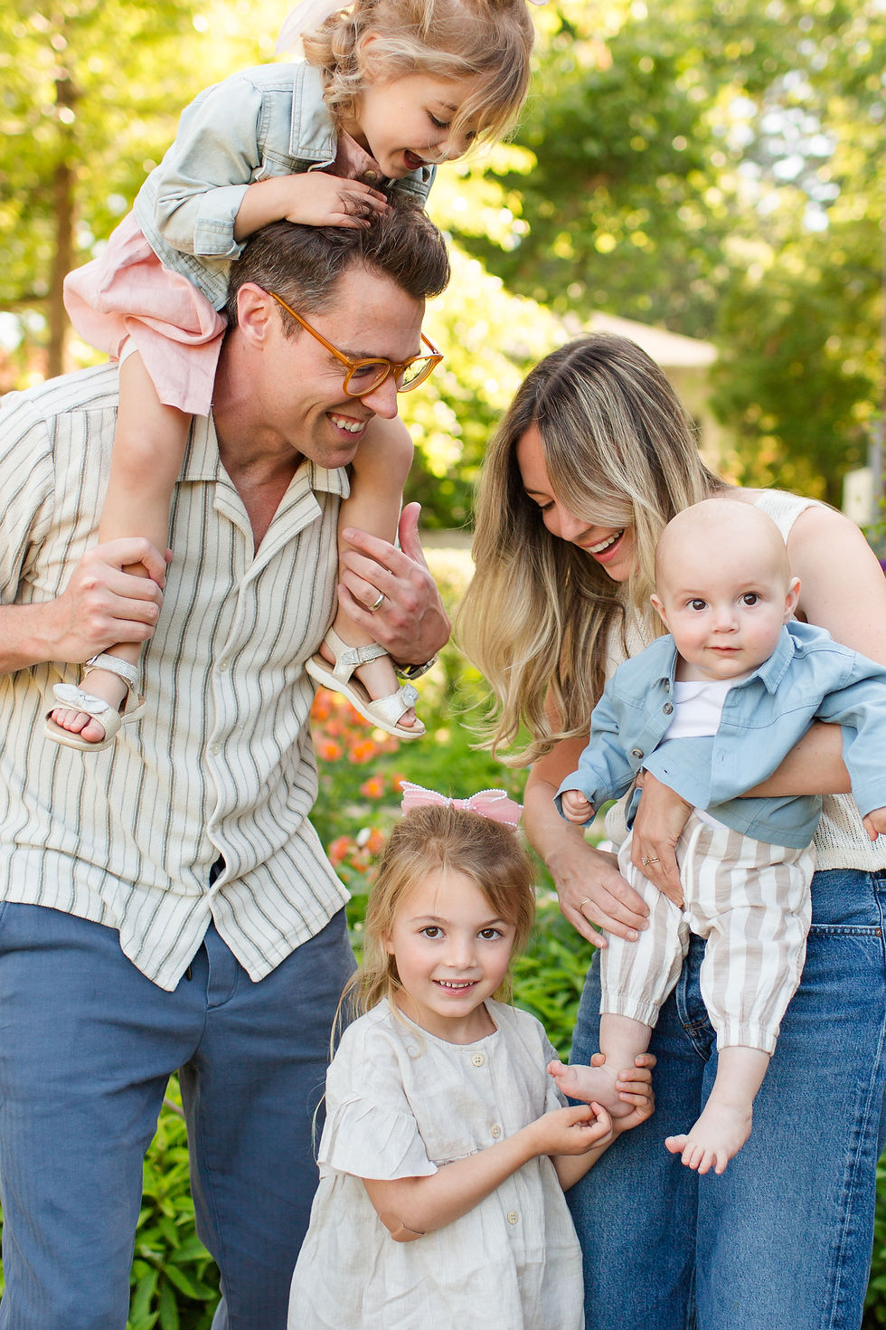 Happy family of five in a sunny garden, father with girl on shoulders, mother holding baby, young girl standing and smiling
Spring Family Photoshoot at Elizabeth Gamble Garden, Palo Alto by Bay Area Photographers HKCreate