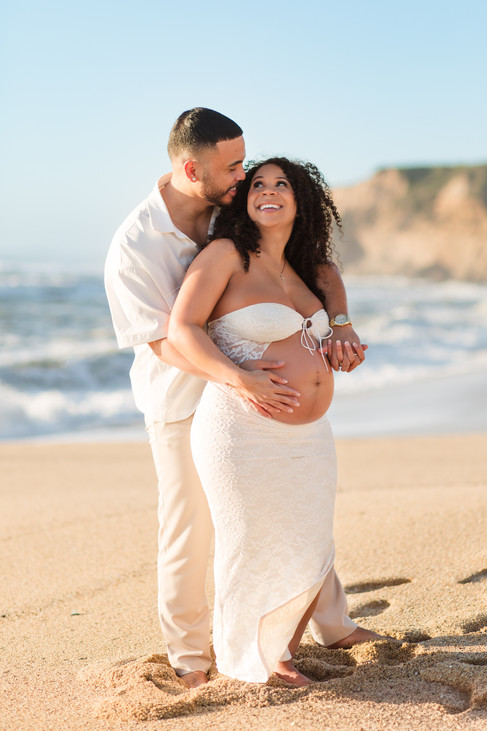 A sweet maternity photoshoot along the beach at cowell ranch state beach in half moon bay during golden hour and sunset. Couple wearing neutral colored outfits hkcreate bay area photographers light and airy photography