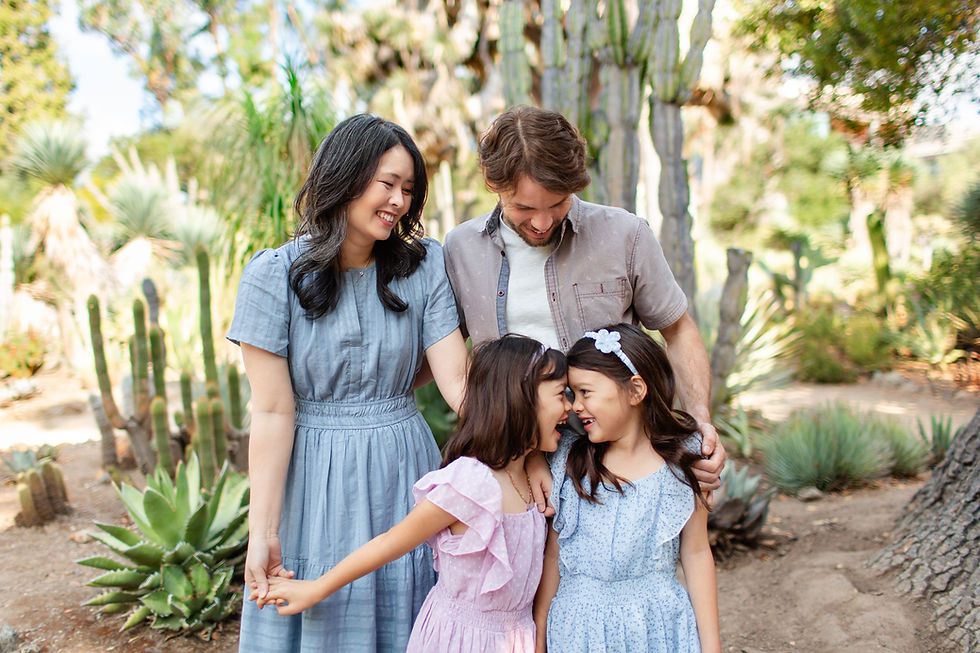 Family of four smiling in a desert garden. Two girls in pastel dresses touch foreheads playfully, surrounded by cacti and greenery.
Summer Arizona Cactus Garden in Los Altos Legacy Extended Family Photoshoot by Bay Area Photographers HKCreate