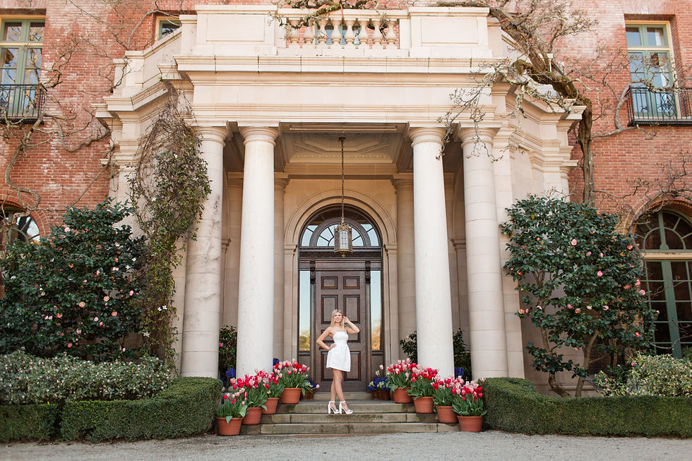 Woman in a white dress poses on steps of a grand entrance with tall columns, surrounded by potted red and pink tulips. Brick building facade.
ABOUT THE LOCATION Guide to Filoli Historic House and Garden, Woodside, California by HKCreate Bay Area Photographers
