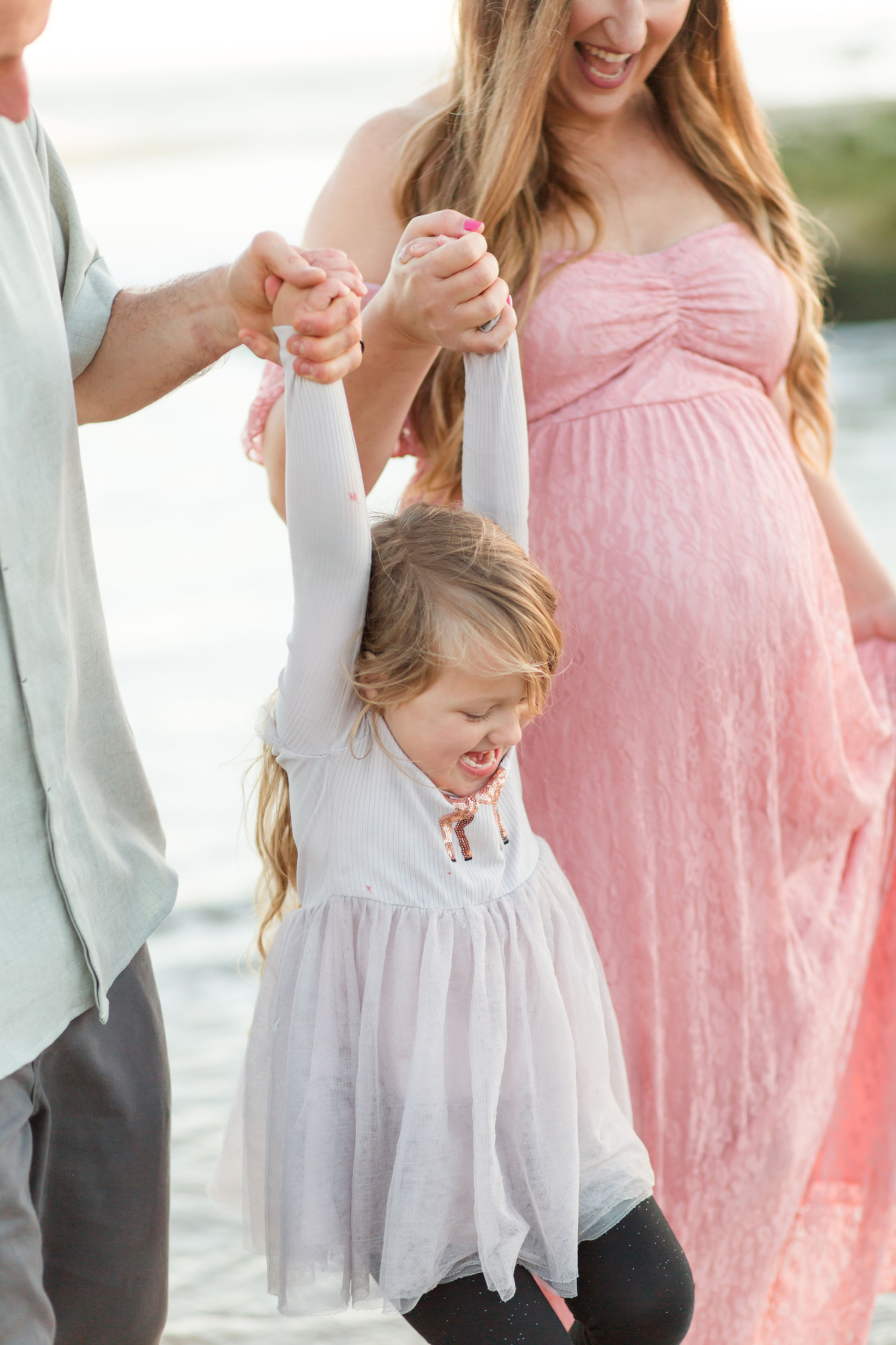 hkcreate bay area photography joyful light and airy san jose photographers northern california photoshoot beach maternity session pink lace dress natural bridges state beach santa cruz family of three swinging little girl