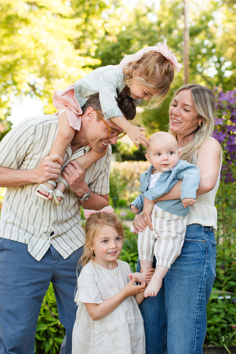 Happy family of five outdoors in a sunny garden, with two parents holding toddlers and two young girls playing close by
Spring Family Photoshoot at Elizabeth Gamble Garden, Palo Alto by Bay Area Photographers HKCreate