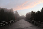 A blue sky with cotton candy clouds setting on a recently rained on bridge. Priceville, ON