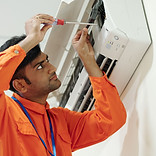 concentrated-young-indian-engineer-orange-wear-using-screwdriver-while-setting-up-air-cond