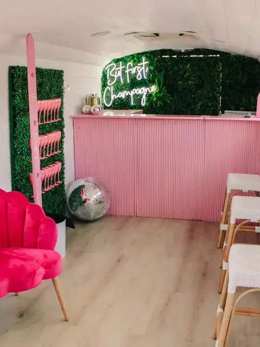 Pink bar inside a mobile Champagne Train with a pink velvet chair
