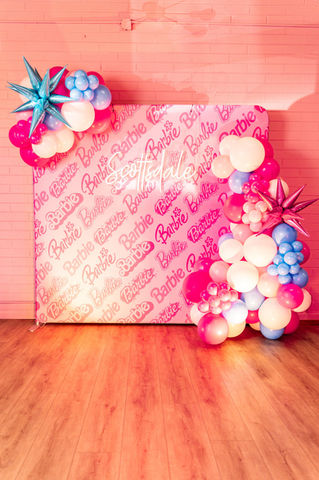 Pink Barbie-themed backdrop with neon 'Scottsdale' sign and balloons