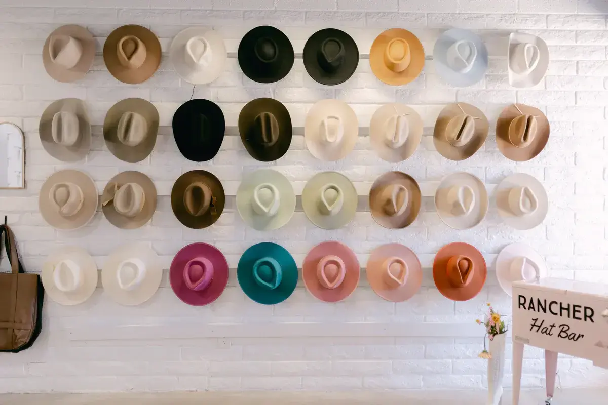 A wall display of colorful rancher hats in various styles