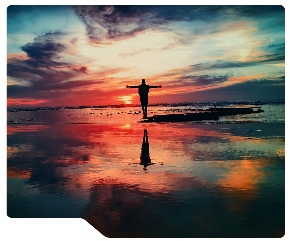 Silhouette of a person standing with arms outstretched on a reflective beach at sunset, vivid red, orange, and blue clouds, representing a Zoek Marketing client's 30-day transformation.