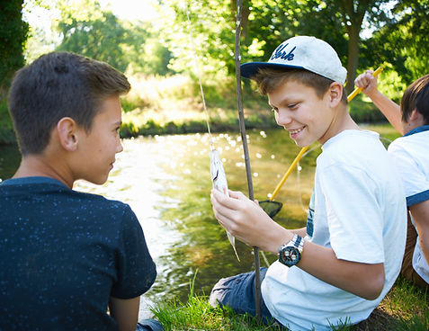 Boys holding fish while fishing