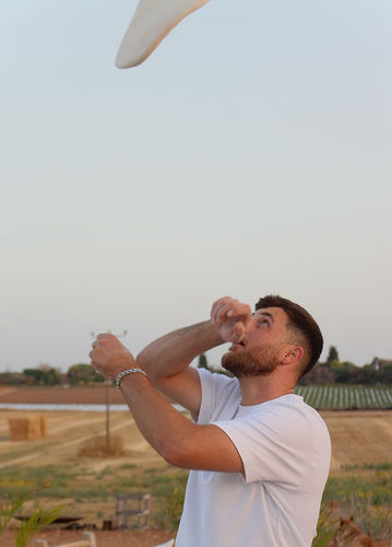 גבר צעיר תופס פיצה באוויר