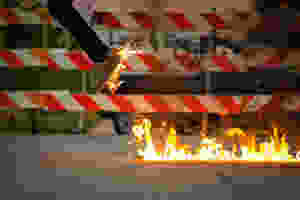 Springender Mensch mit Schuhen, die in Flammen stehen.