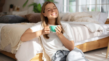 Healthy woman relaxing in the sun drinking coffee