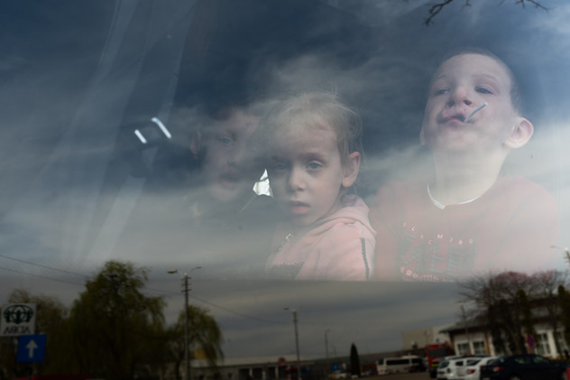 April 2022 | Siret, Romania. Three kids part of an evacuation organized for disabled, orphans and autistic minors on a coach at the Ukrainian-Romanian border. The group was put together to evacuate from the Rivne region.
