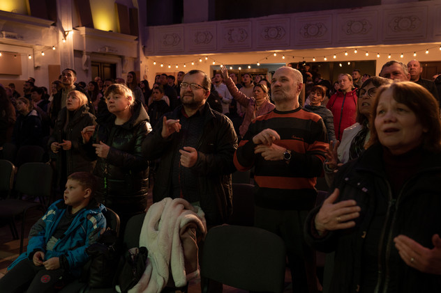 April 2022 | A group of displaced Ukrainians takes part to the Easter mass in a church in Chernivtsi. The people in the first row are deaf or hard of hearing and they are singing using the signs language.