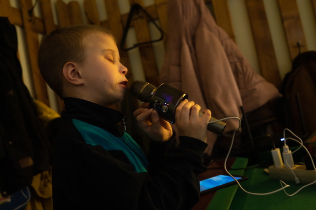 April 2022 | Sergiy, 10 years old, sings at the Caritas center in Siret. Sergiy loves his microphone and he would like to become a dj, playing music and combining colourful lights with it.