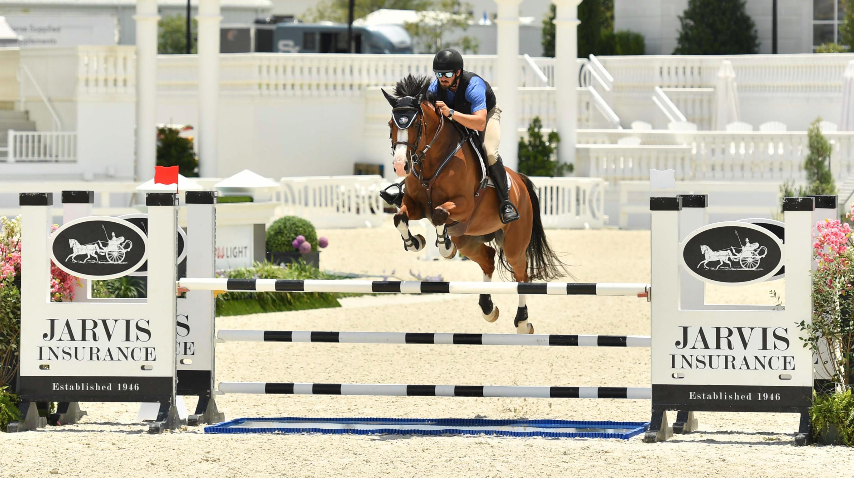 Show jumping rider clearing an oxer