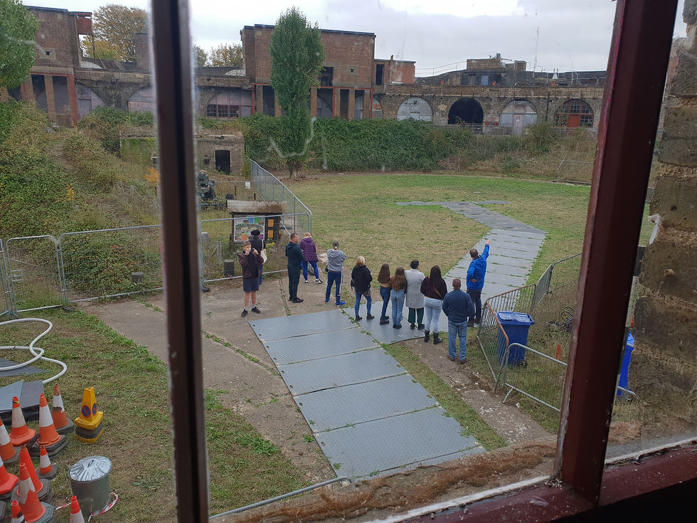 Visitors entering Coalhouse Fort parade ground. The space is open and green, cleared for visitors.