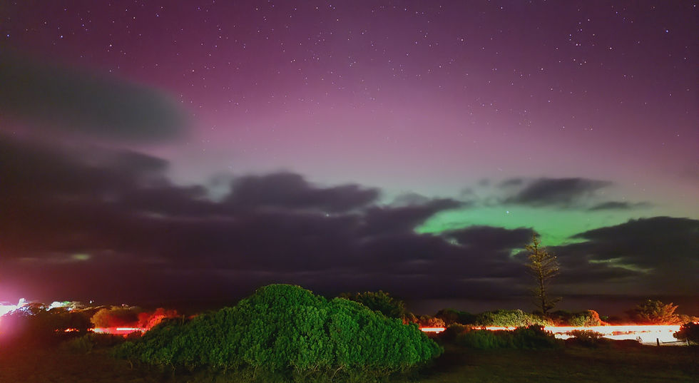Wide angle view of a starry night sky with vibrant green auroras