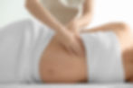 Young beautiful pregnant woman having massage in spa salon.jpg