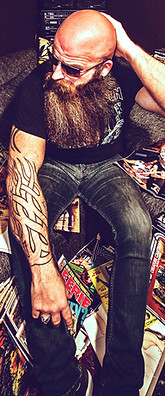 Rikk Currence of War Gods of the Deep surrounded by his comic book collection