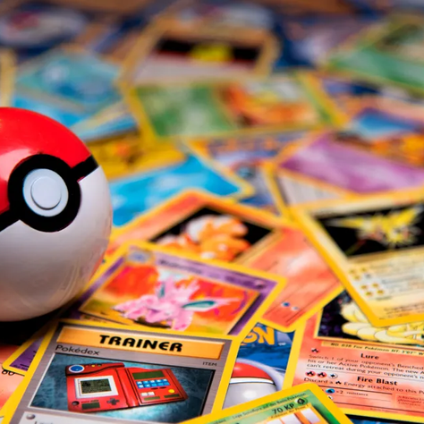 Collection de cartes Pokémon ultra rares – Dracaufeu 1st Edition, Pikachu Illustrator, Kangourex Trophy et Lugia Neo Genesis – présentées sur un stand lors d’un salon dédié aux collectionneurs.