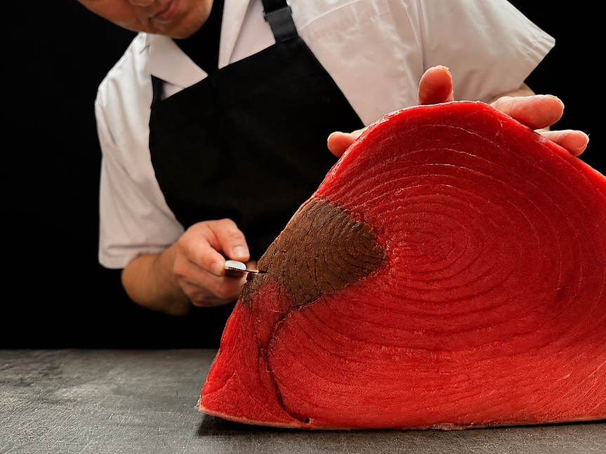 Sushi chef slicing fresh bluefin tuna