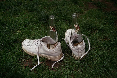 Empty beer bottles inside of a pair of sneakers. A summer self-portrait, shot using Kodak Ultramax 400 film. 