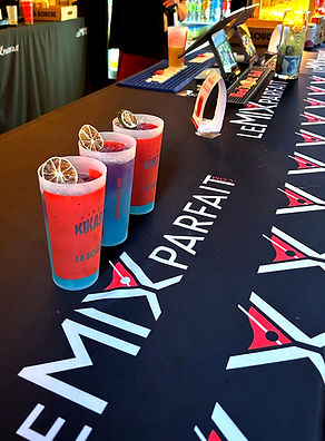 3 cocktails signature bleu et mauve dans des verres personnalisés sur le comptoir de la mix mobile