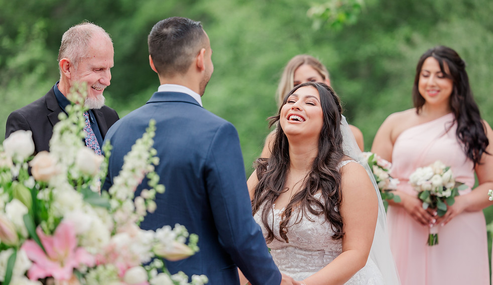 bride and groom sharing a laugh at the wedding altar