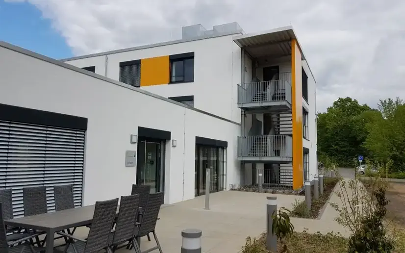 Ansicht auf Außenanlage mit Gehwegen aus Natursteinen und Bepflanzung.