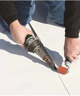 Roofing contractor installing flat roofing materials according to project specifications