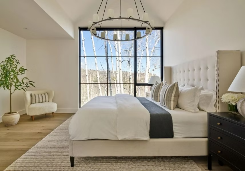 Sophisticated primary suite with upholstered bed sitting on large rectangular rug. Project Image: Faraway Road