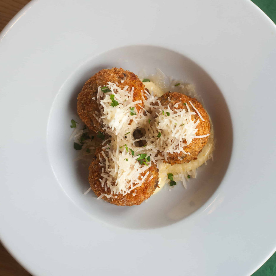 Casa's cheese bon bons in a large bowl with grated parmesan