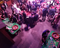 Image of casino tables and people playing.