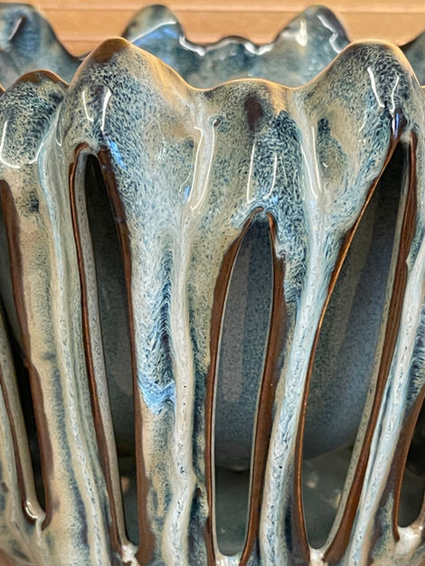 Close-up of a sculptural blue ceramic vessel from the LEH Curated collection, featuring artisanal dripped glazing and layered texture.