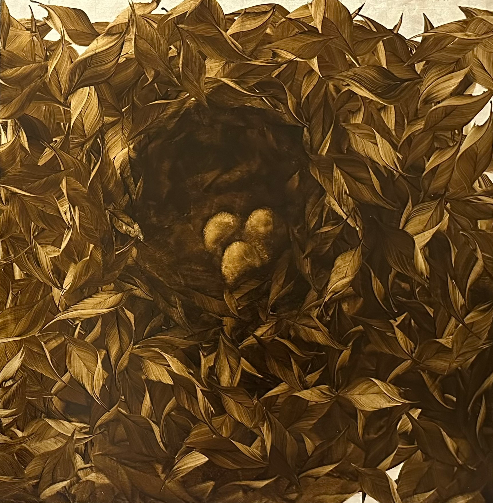 Nest mit drei goldenen Eiern, umschlossen von sepiafarbenen Blättern