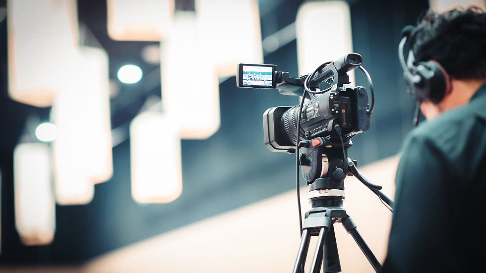 Kameraoperator filmt mit Videokamera auf Stativ in einem Studio