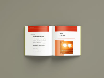 A magazine-type book is laid open and features orange and red shapes, text, and car headlight image