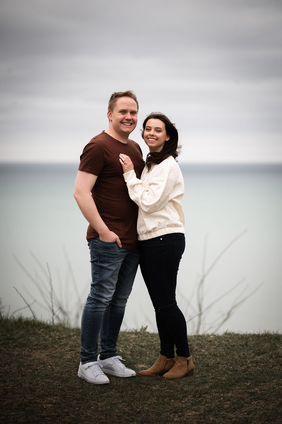 man and woman standing outdoors lake in background smiling at Retzer Nature Center in Waukesha Wisconsin