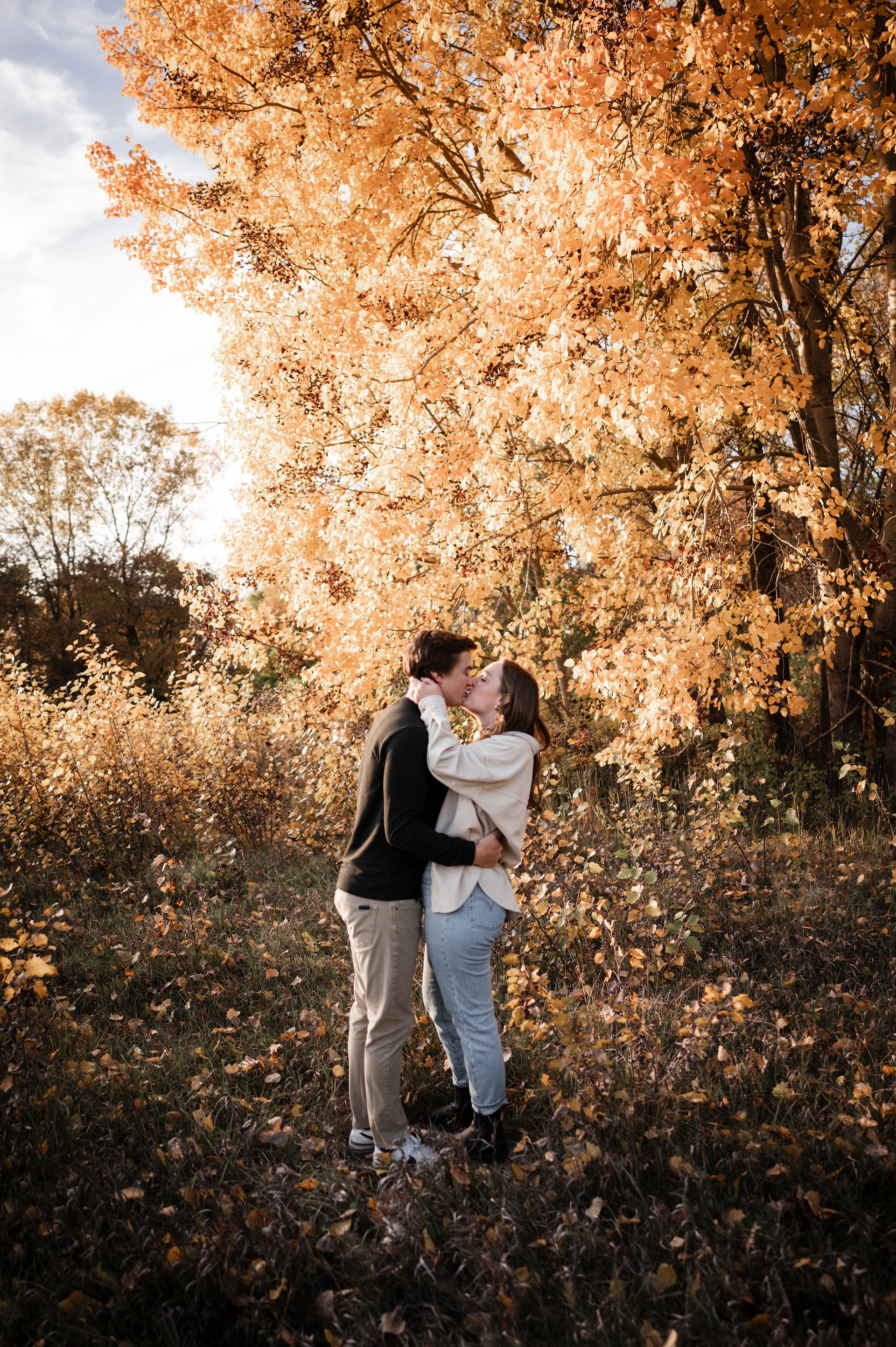 man and woman kissing surrounded by yellow fall foliage in Lodi Wisconsin