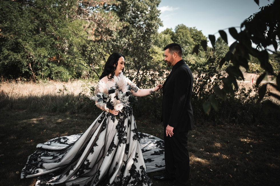 bride adjusting groomsmens suit outdoors at Whispering Pines Event Center in Poynette Wisconsin